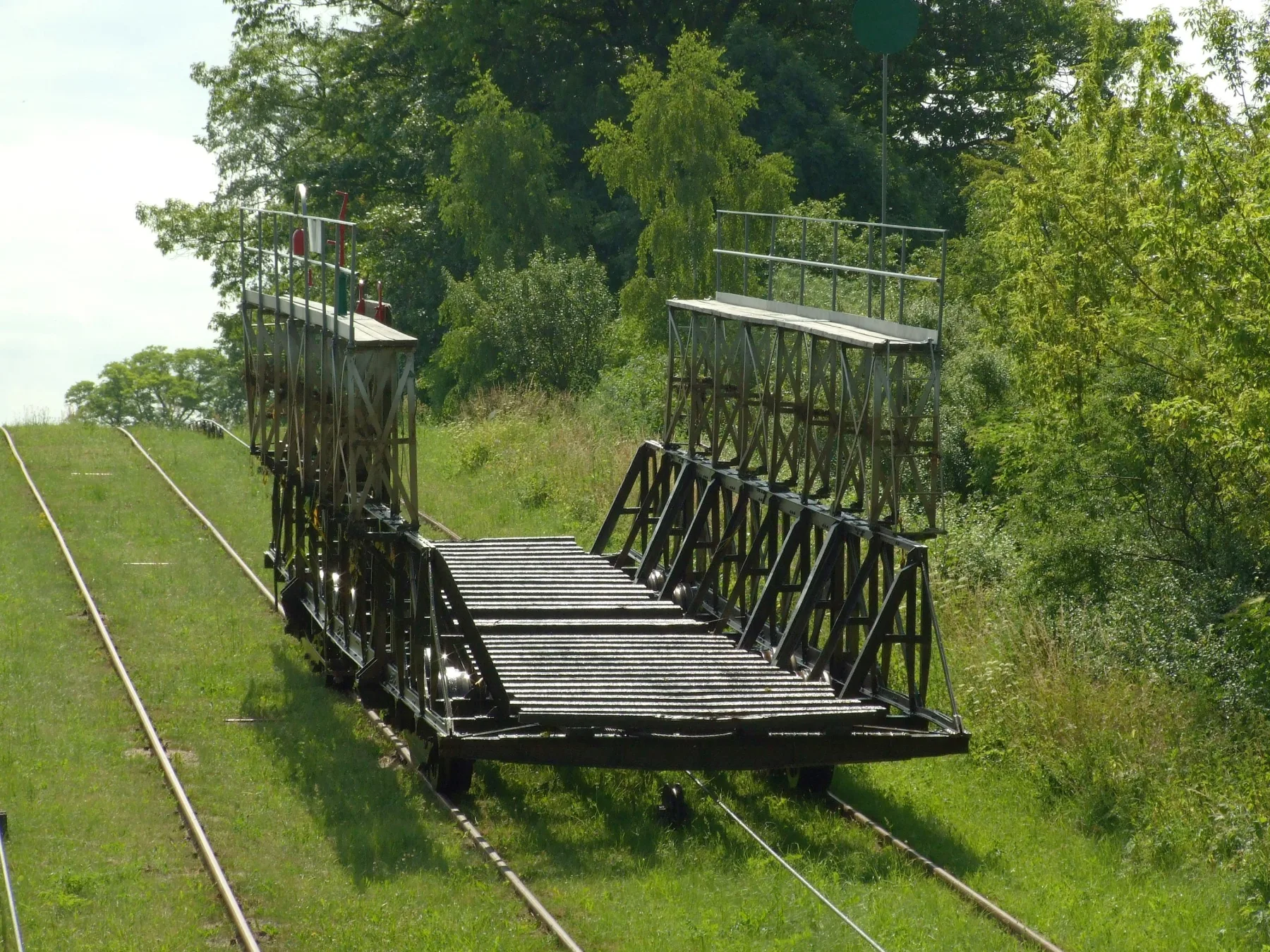 Pełny pusty wózek pochylni Całuny ustawiony na szynach, widok ramowo-kratowej konstrukcji i podwozia